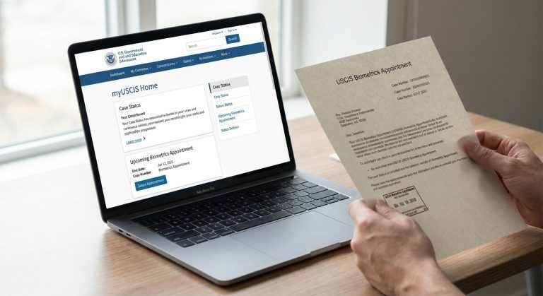 A laptop showing the myUSCIS portal beside a biometrics appointment notice.