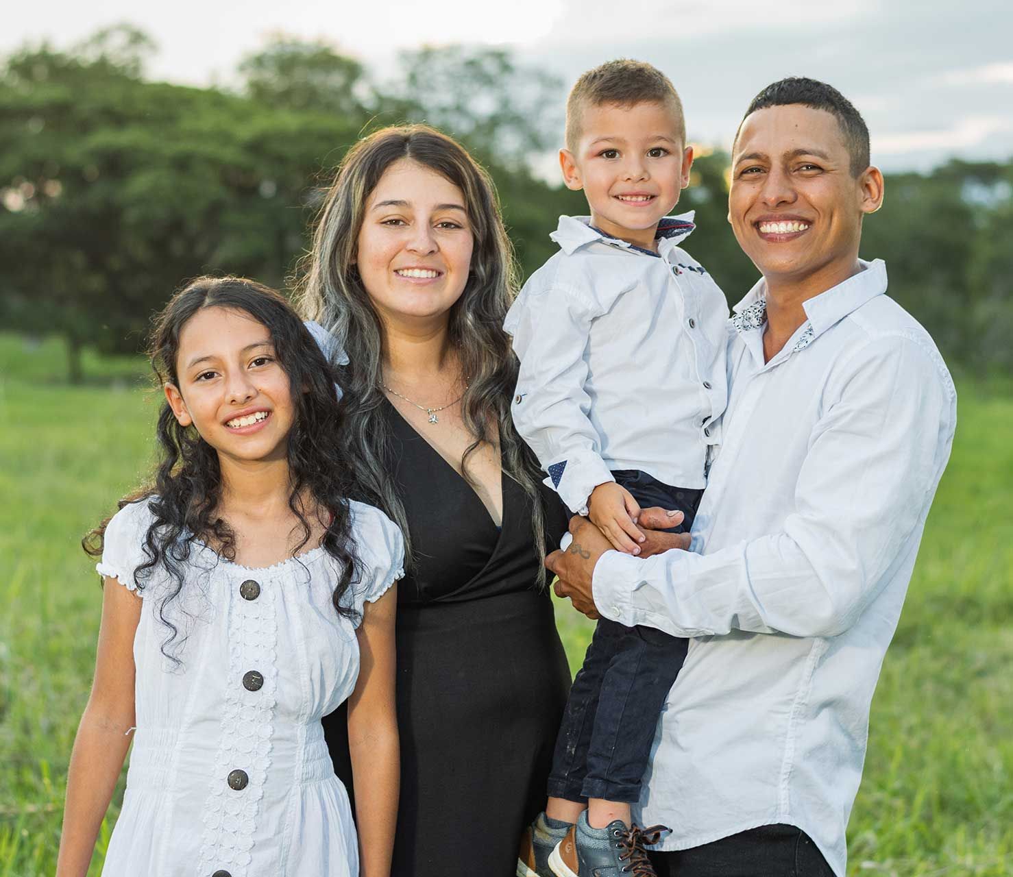 Family of four smiling together outdoors